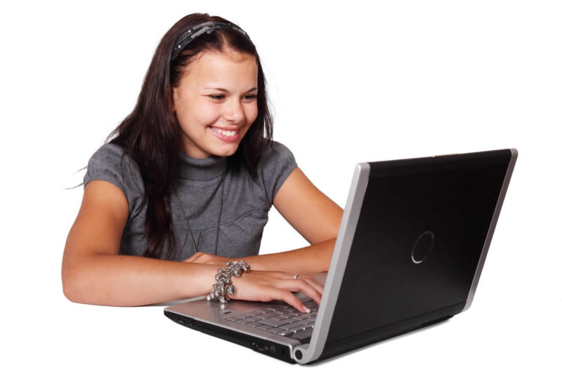 Young woman smiling looking at her laptop