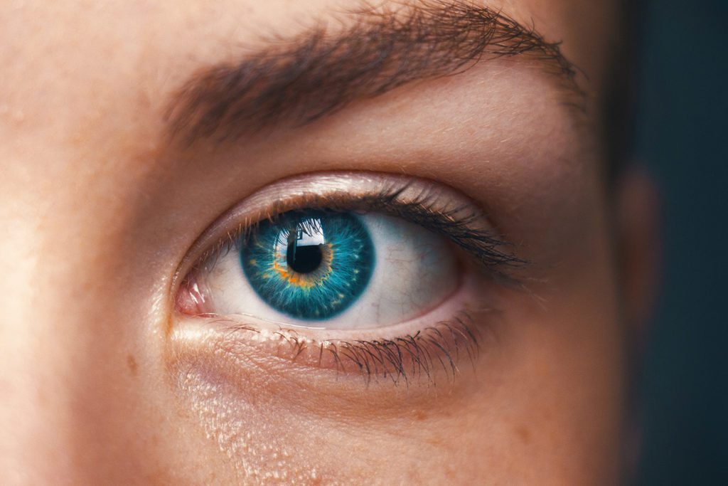 A blue eye of a young woman showing the importance of healthy eyes